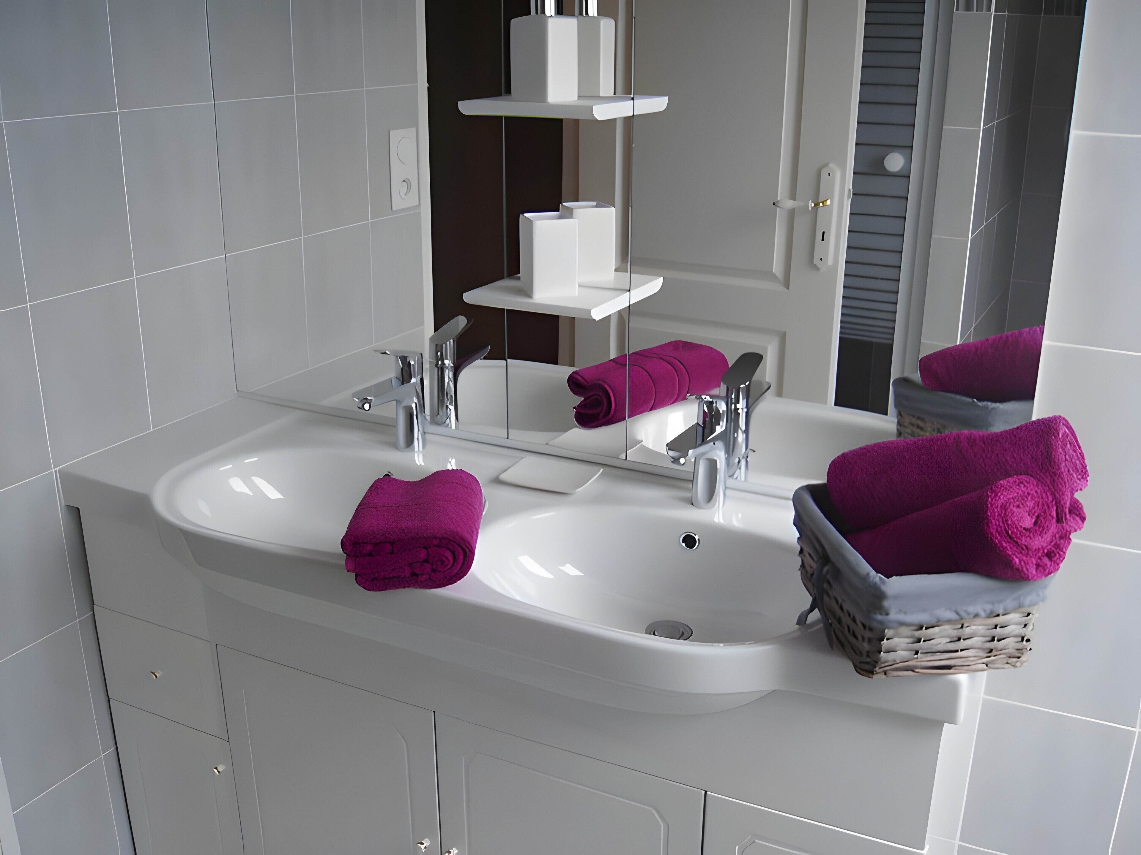 A bathroom with a white sink, two faucets, a mirror, and a wicker basket with towels.
