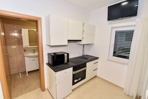 A compact kitchen with a microwave, sink, and oven.