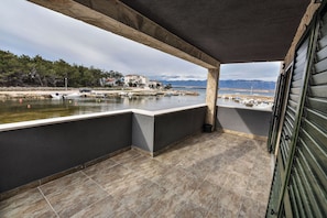 A balcony with a view of a calm body of water, boats, and distant mountains. - Seaside Oasis on Island Vir With Private Pool and Ocean Views (Vir)