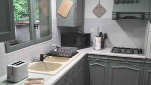 A kitchen with a sink, a toaster, a microwave, and a stove.
