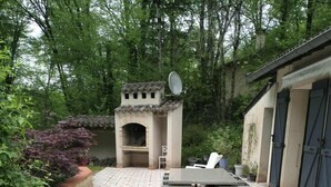 An outdoor patio area with wicker furniture, a built-in grill, and a satellite dish.