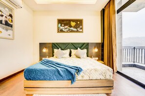Ein Schlafzimmer mit einem Bett, einem Bild und Blick auf einen Balkon.