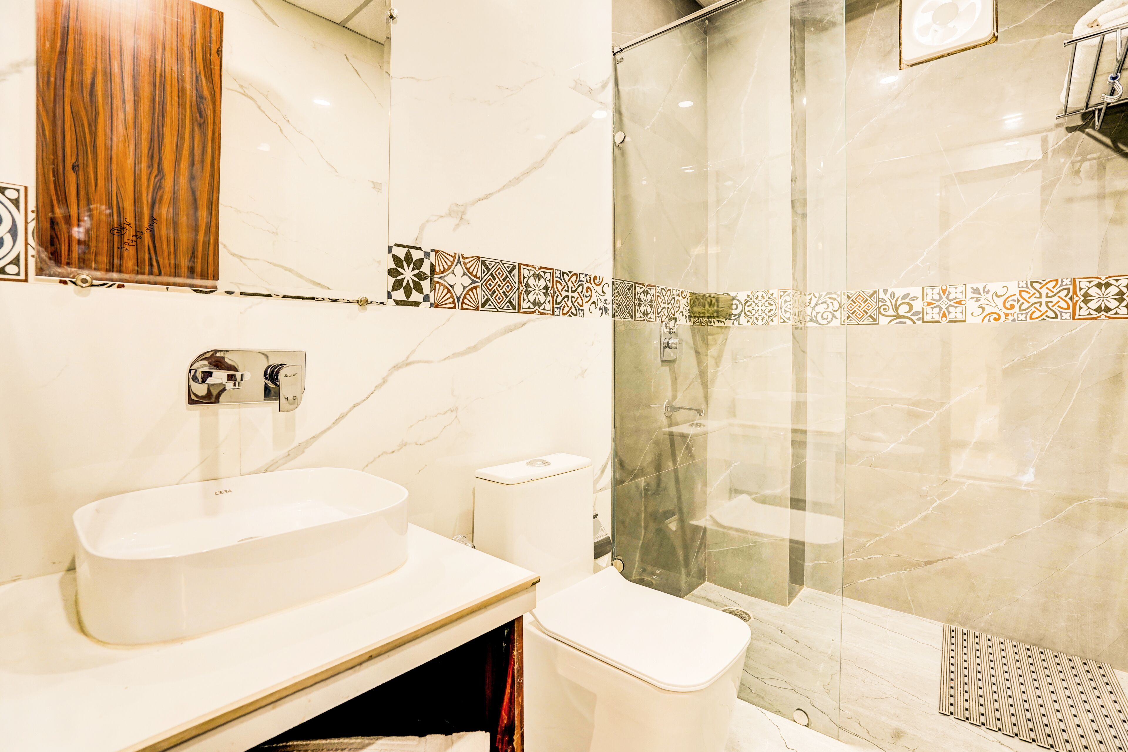 Une salle de bain avec un lavabo en marbre, des toilettes et une douche à parois de verre.