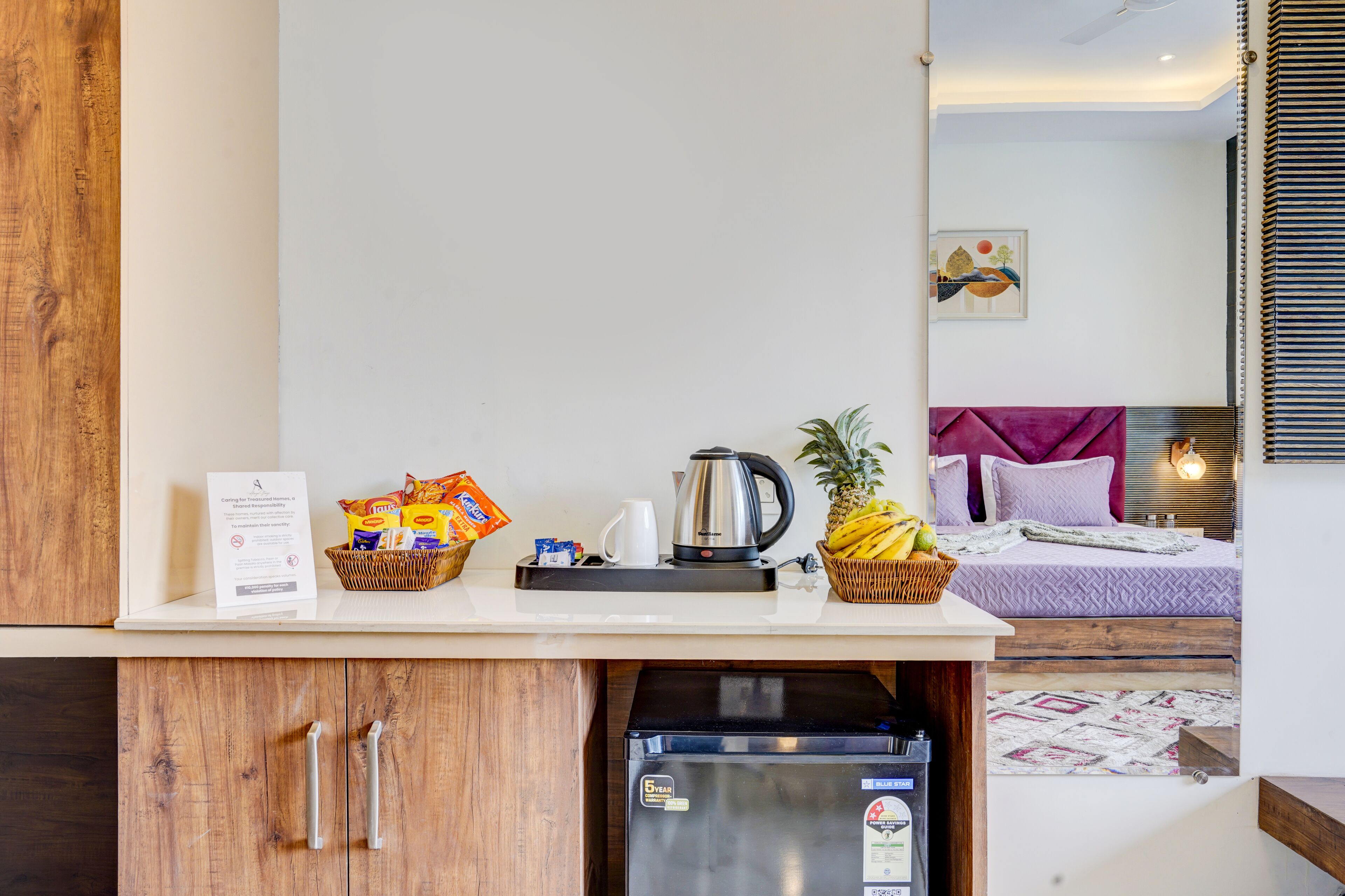 Une petite cuisine équipée d’une machine à café, d’un panier de collations et d’un réfrigérateur.