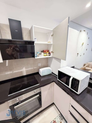 Fridge, microwave, coffee/tea maker, cookware/dishes/utensils
