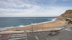 A coastal road with a beach and cliffs.