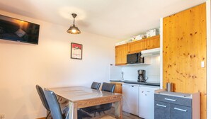 A compact kitchen with wooden cabinets, a microwave, a coffee maker, and a dishwasher.