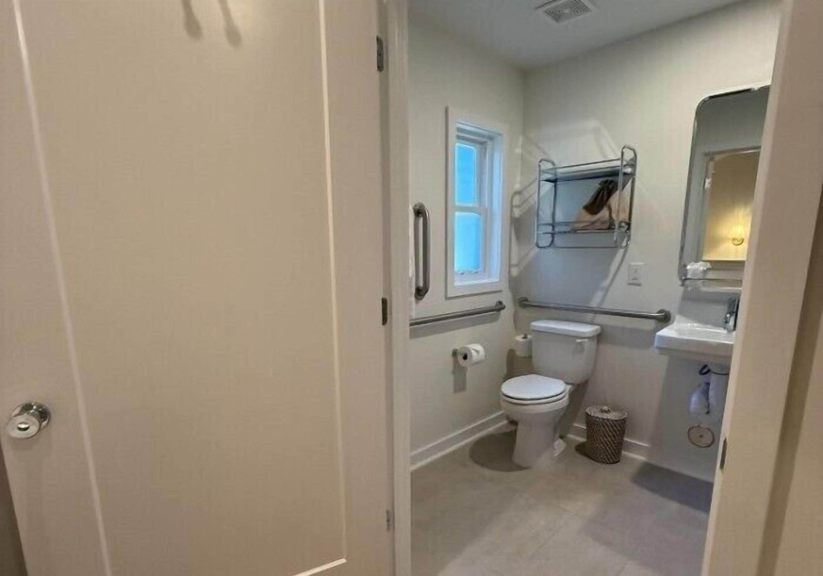 A compact bathroom with a toilet, sink, and window.