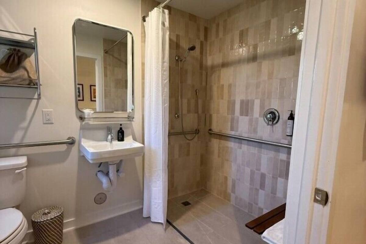 A bathroom with a shower, a sink, and a toilet.