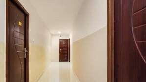 A hallway with two doors, one on each side, leading to a room. - Five stones By Terra Hotel T Nagar (Chennai)