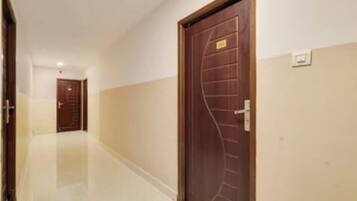 Un pasillo con una puerta de madera a la derecha y otra al final.