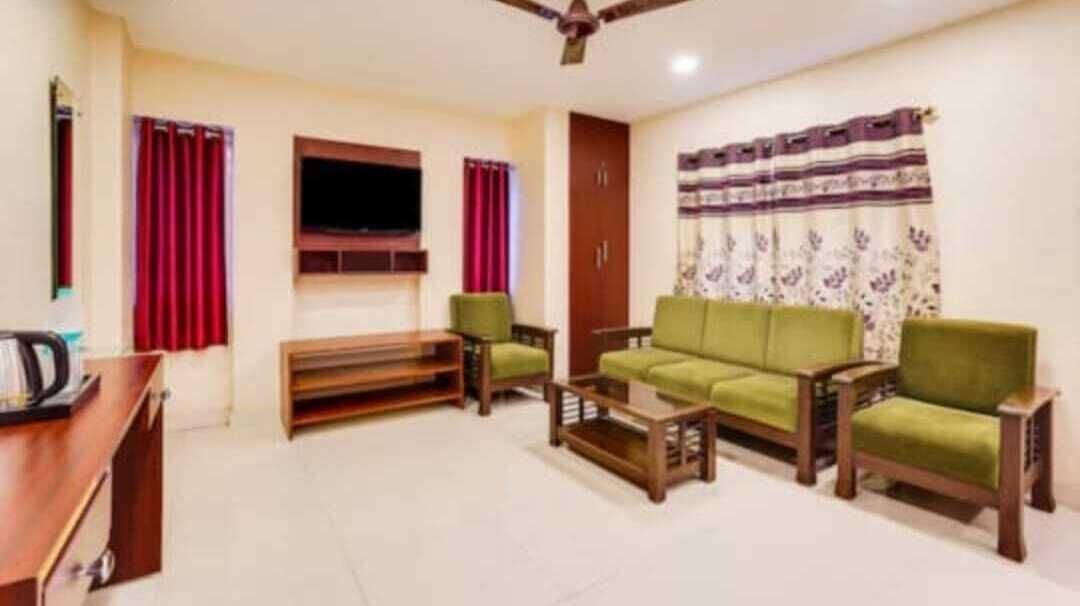 Un salon comprenant un canapé, deux fauteuils, une table basse et un téléviseur.