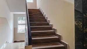 A staircase with wooden steps and a marble wall. - Five stones By Terra Hotel T Nagar (Chennai)
