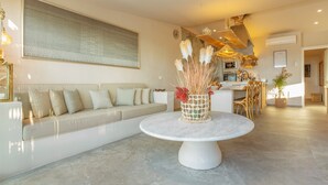A modern living room with a round table, a sofa, and a kitchen in the background. - Villa Oceania Entire with Sea View, Wi-Fi and Air Conditioning (Chayofa)