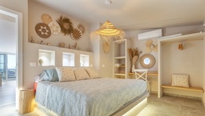 A modern bedroom with a bed, bedside tables, a hanging light fixture, and decorative wall art. - Villa Oceania Entire with Sea View, Wi-Fi and Air Conditioning (Chayofa)