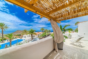 Un balcón con vistas a una piscina y un paisaje montañoso.