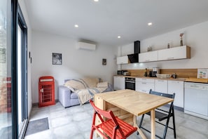 A compact living space with a dining area, kitchenette, and a red telephone booth.