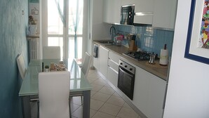 A kitchen with white cabinets, a stove, and a sink.
