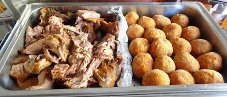 A buffet with pulled pork and cheese balls.