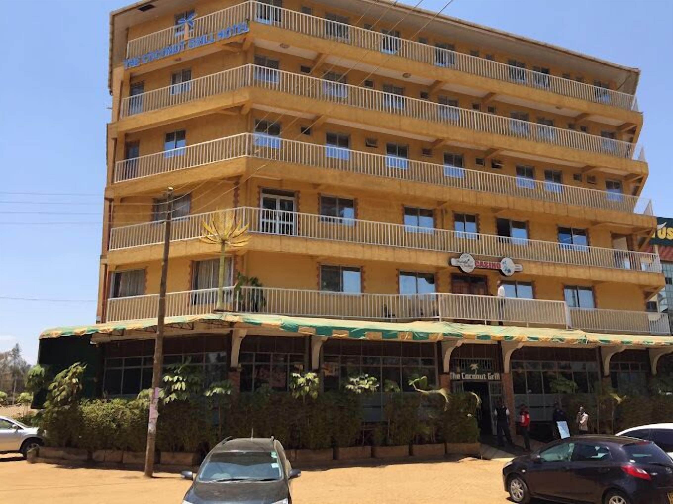 Un hotel de varios pisos con balcones y un restaurante en la planta baja.