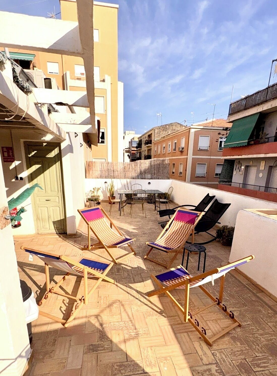 Una terrazza esterna con due poltrone, un tavolo e un divano.