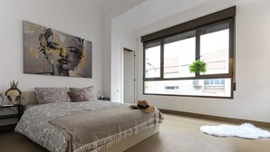Ein Schlafzimmer mit einem großen Bett, einem Fenster mit Blick und einem Bild an der Wand.