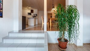 Un escalier menant à une salle à manger où se trouve une plante en pot.