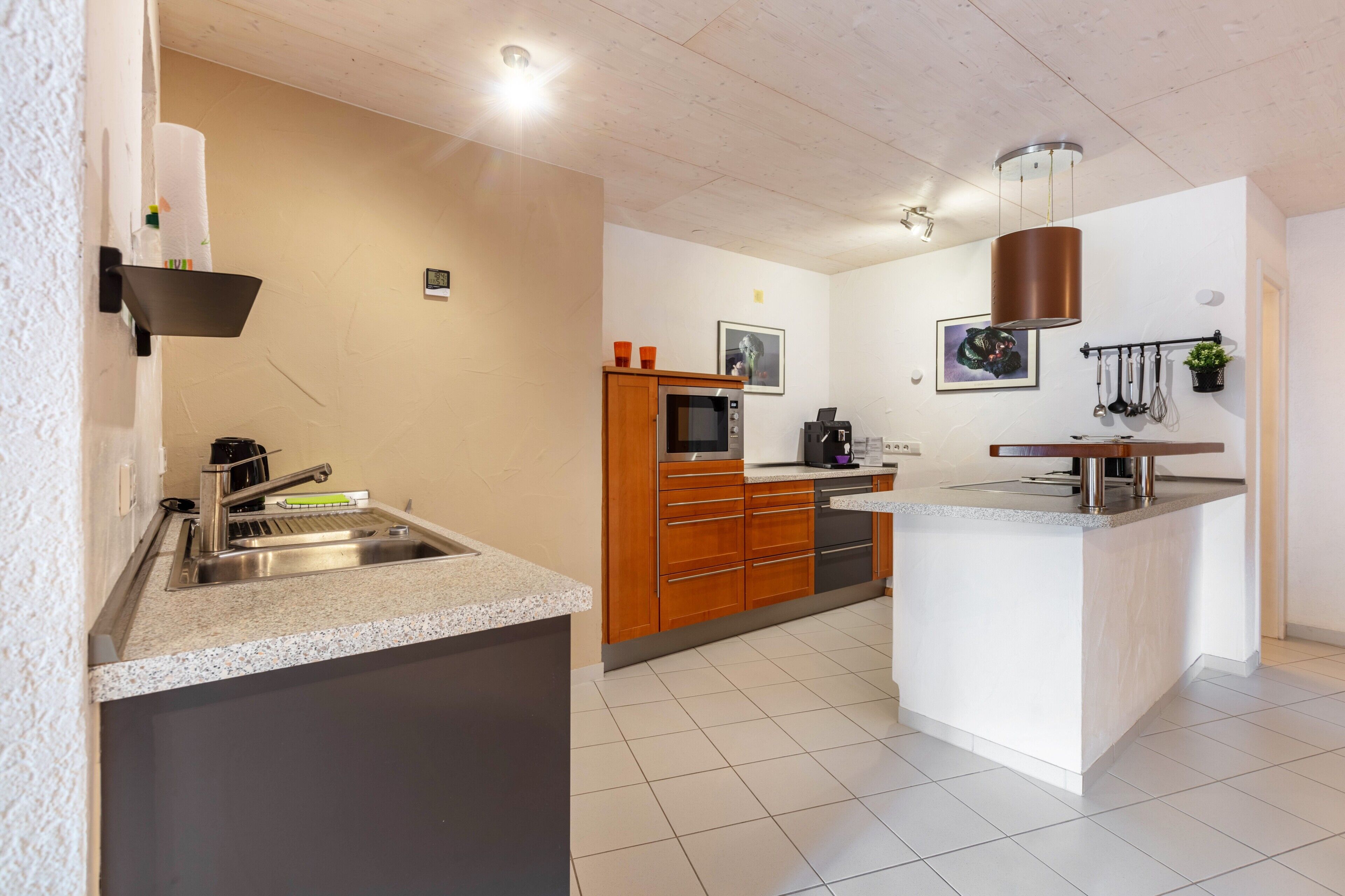 A modern kitchen with a built-in oven, microwave, and sink.