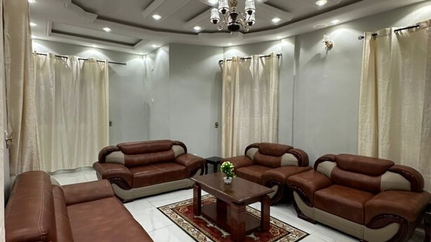 A modern living room with a brown leather sofa, a matching armchair, and a coffee table.