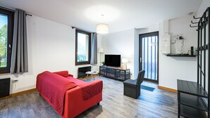 A room with a bed, a desk, a TV, and a window.