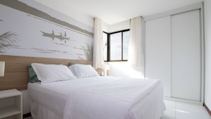 Un dormitorio con cama, mesita de noche, ventana con cortinas y un mural en la pared.