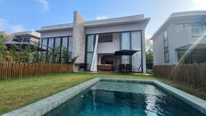 Una casa moderna de dos pisos con piscina en el patio trasero.