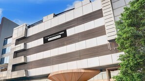 A multi-story building with a sign indicating it is a serviced apartment complex. - Suite JM Road Krishna Presidency (Pune)