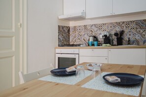 Réfrigérateur, un four, surface de cuisson, vaisselle et ustensiles