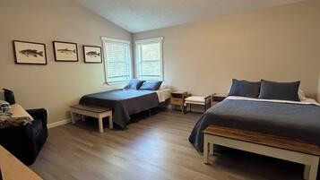 A bedroom with two beds, a ceiling fan, and framed fish pictures on the wall.
