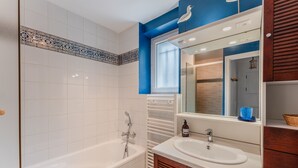 Un baño con bañera, lavabo y espejo.