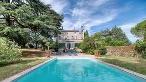 A swimming pool with a view of a large house and trees. - Villa Corbière - Piscine Privée (Castres)