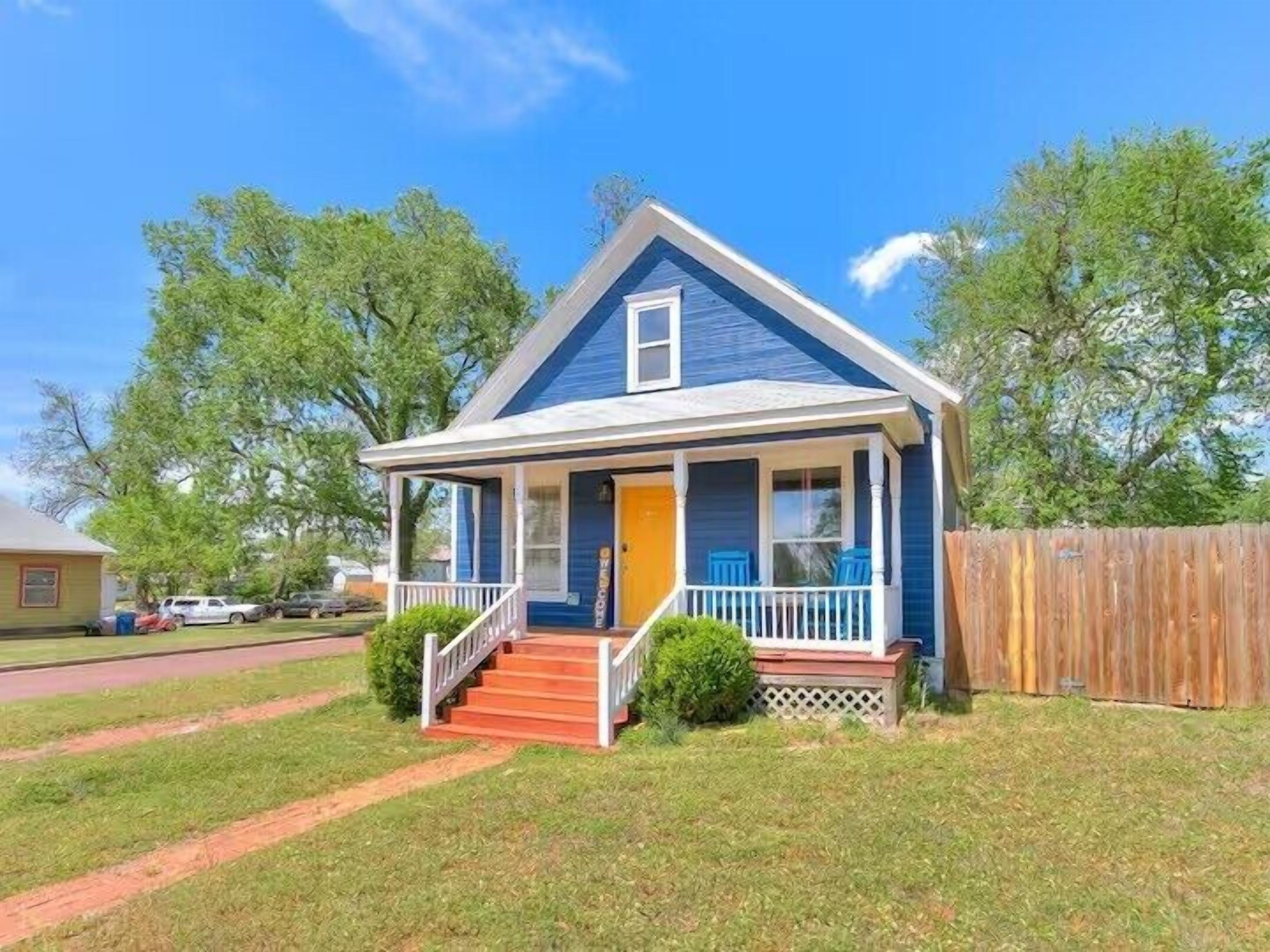 A single-story house with a porch, a front door, and a small front yard.