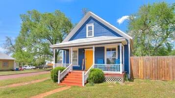 A single-story house with a porch, a front door, and a small front yard.