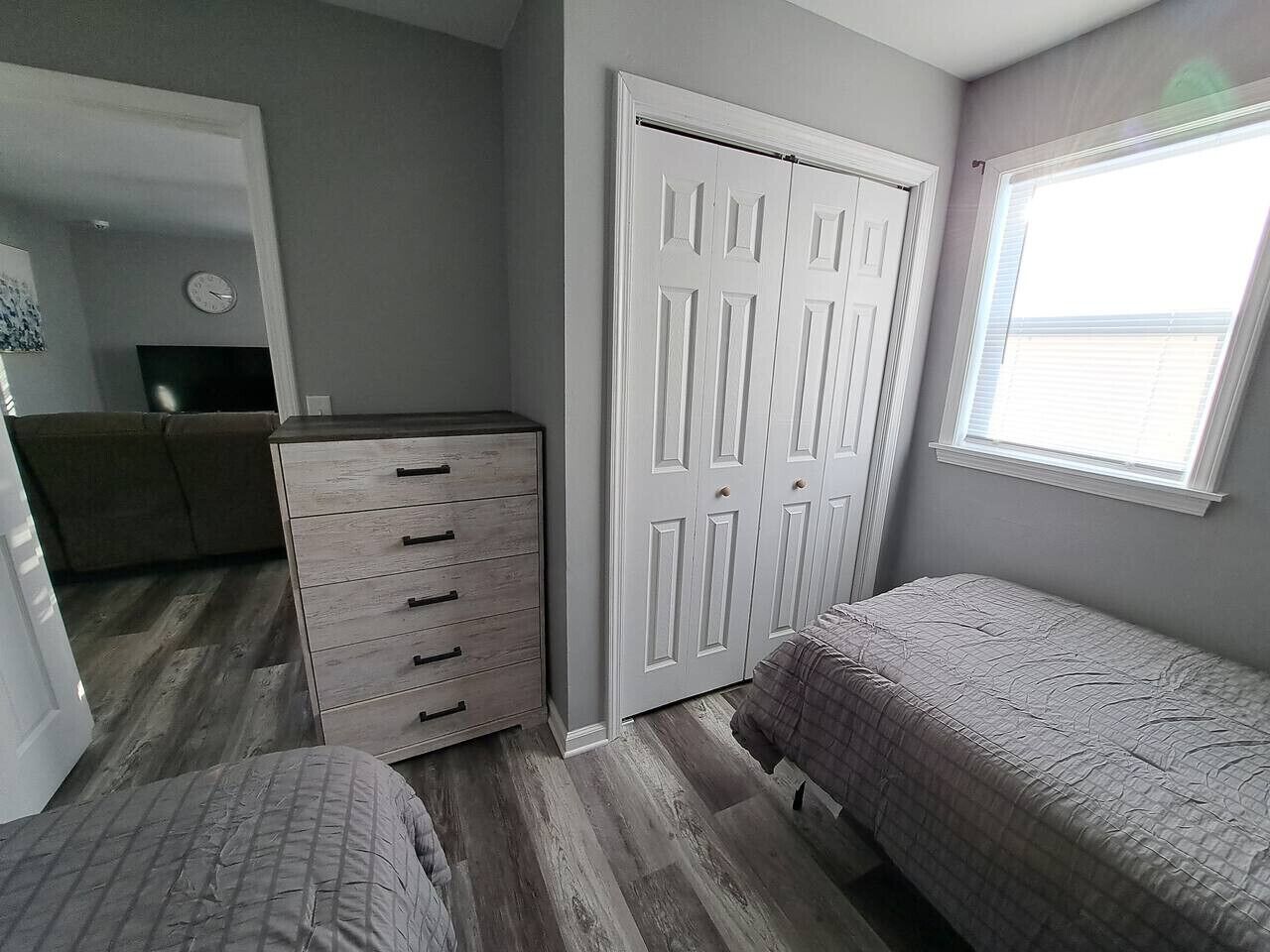 Un dormitorio con cama, cómoda y armario.