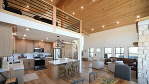 A spacious kitchen with wooden cabinets, a central island, and a dining area with a wooden table and chairs.