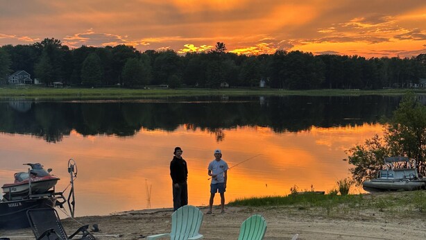 Un entorno junto al lago con sillas, una hamaca y una caña de pescar, evocando un espacio de esparcimiento.