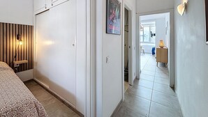 A hallway with a bed, wardrobe, and a door leading to a balcony. - GR CANAL 19 Roses / Roses - INTERimmo (Rosas / Roses)