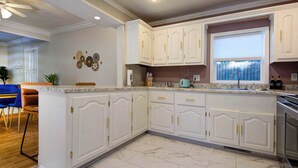 A kitchen with white cabinetry, a marble countertop, and a window with blinds. - Charming & Cozy 3-bedroom house in wonderful Springfield with AC (Springfield)