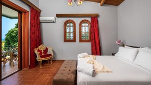A bedroom with a bed, a bench, a chair, two windows, and a ceiling fan.