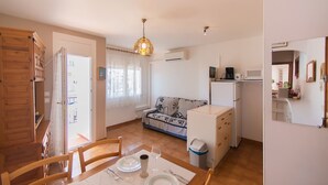 Un espace de vie compact comprenant un coin repas, une kitchenette et un canapé.