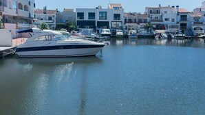 Un port de plaisance où sont amarrés des bateaux, entouré d’immeubles à plusieurs étages dotés de balcons et de grandes fenêtres.