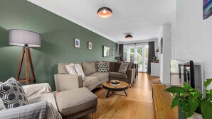Una sala de estar moderna con un sofá modular, una mesa de centro redonda y una lámpara de pie.