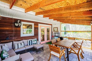 A wooden interior with a wooden ceiling, a sofa, a table with chairs, and a fan. - Waterfront Oasis with Boat Lift & Hot Tub in Bokeelia (Bokeelia)