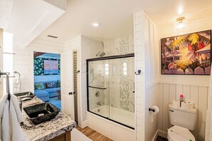 A bathroom with a glass-enclosed shower, a sink with a marble countertop, and a toilet. - Waterfront Oasis with Boat Lift & Hot Tub in Bokeelia (Bokeelia)
